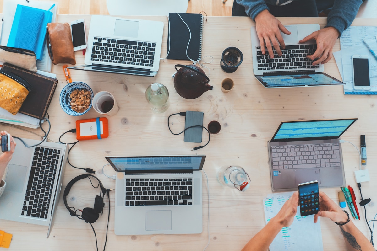 Team collaborating with laptops in a workspace